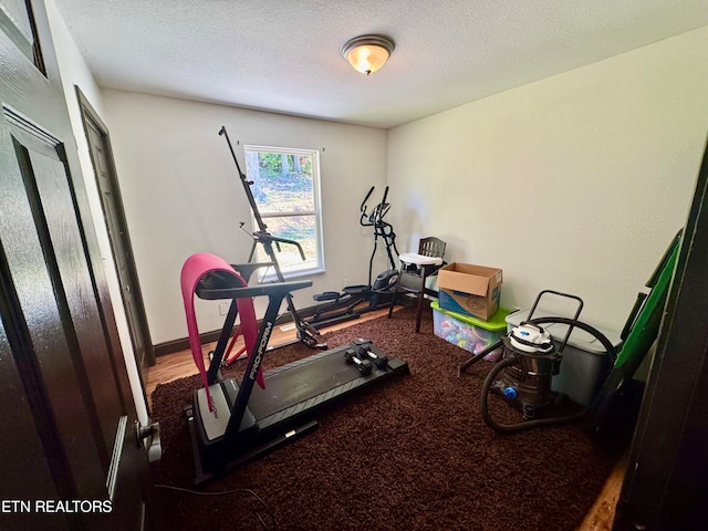 workout room featuring a textured ceiling