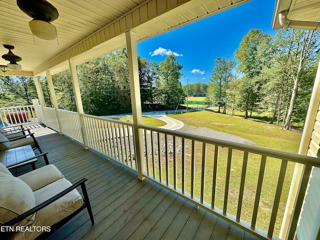 wooden terrace featuring a lawn and ceiling fan