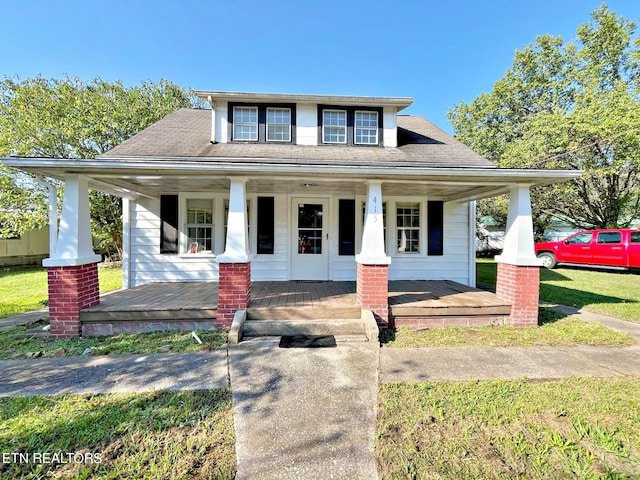 view of front of property with covered porch and a front yard