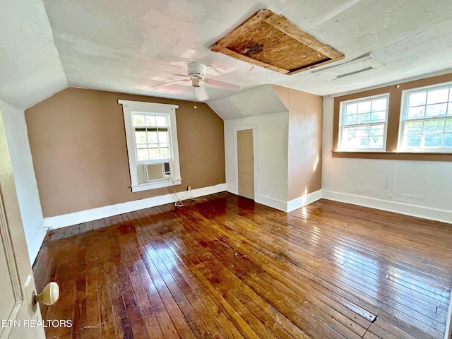 additional living space featuring lofted ceiling, dark hardwood / wood-style floors, and a wealth of natural light