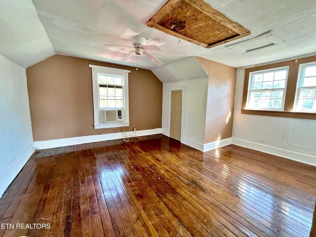 additional living space featuring a wealth of natural light, vaulted ceiling, and dark hardwood / wood-style flooring