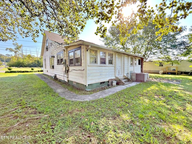 view of front of property featuring central air condition unit and a front yard