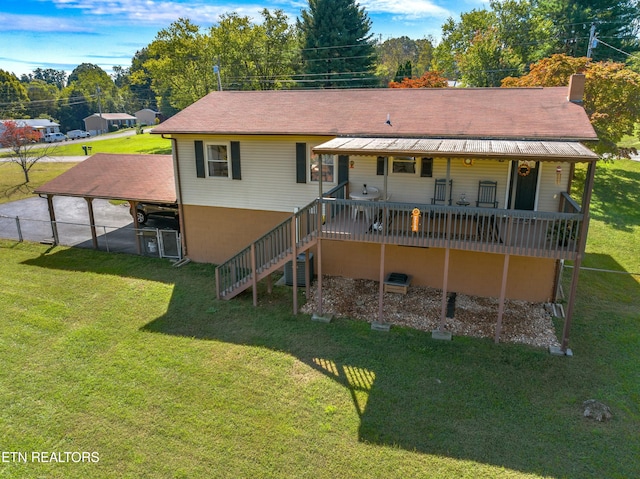 rear view of house with a carport and a yard