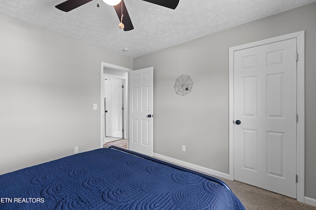 unfurnished bedroom with carpet, ceiling fan, and a textured ceiling