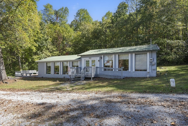 single story home featuring french doors and a front lawn