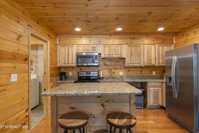 kitchen with light stone counters, sink, stainless steel appliances, and light brown cabinetry