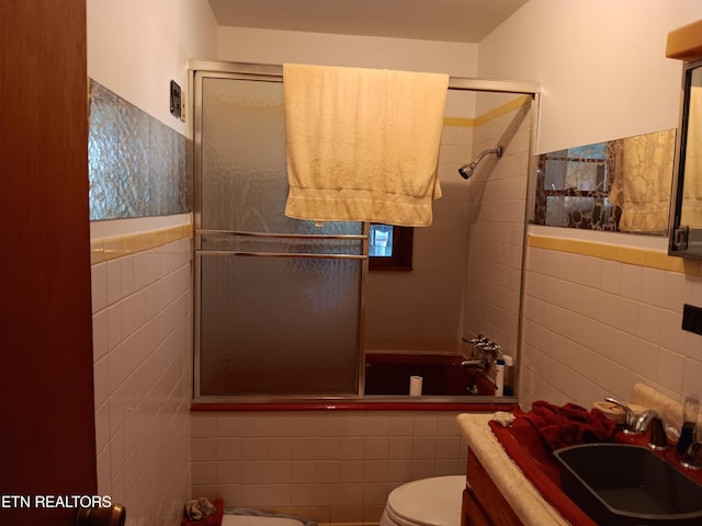 bathroom featuring walk in shower, tile walls, vanity, and toilet