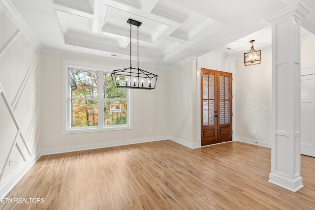 unfurnished dining area with a notable chandelier, crown molding, light wood finished floors, decorative columns, and baseboards