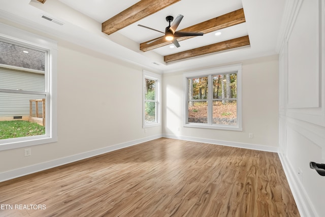 unfurnished room with visible vents, baseboards, light wood-type flooring, beam ceiling, and a ceiling fan