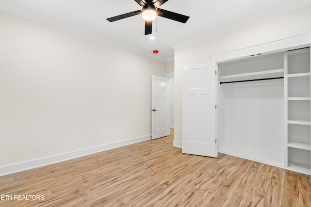 unfurnished bedroom with a ceiling fan, baseboards, light wood-style floors, a closet, and crown molding