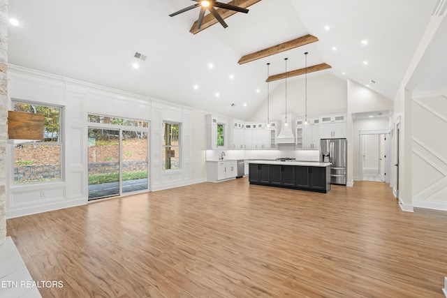 unfurnished living room featuring light wood-type flooring, beamed ceiling, high vaulted ceiling, visible vents, and a decorative wall