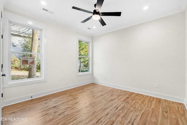 spare room featuring visible vents, baseboards, light wood-type flooring, ornamental molding, and recessed lighting