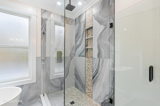 full bathroom featuring a freestanding bath, a marble finish shower, and ornamental molding