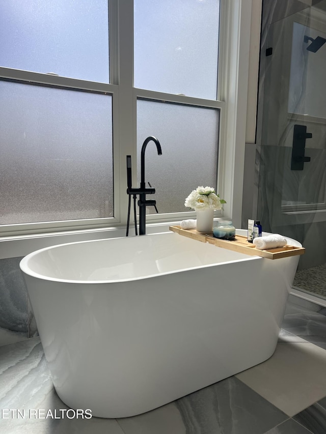 bathroom with a soaking tub and a shower stall