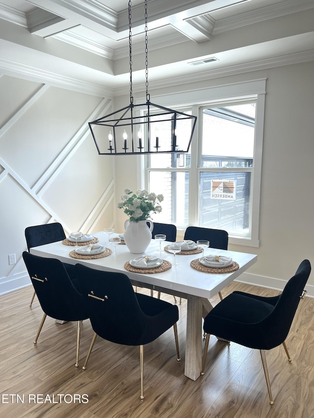 dining area with visible vents, baseboards, light wood-style floors, and ornamental molding