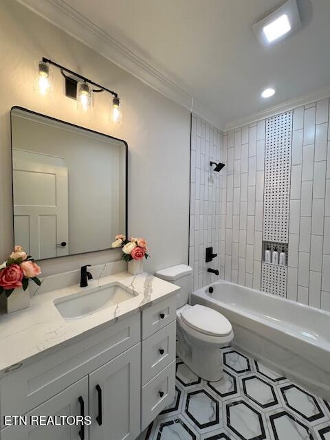 bathroom featuring toilet, ornamental molding, shower / tub combination, tile patterned flooring, and vanity