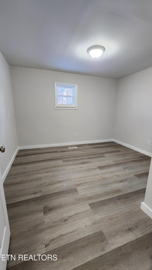 unfurnished room featuring wood finished floors and baseboards