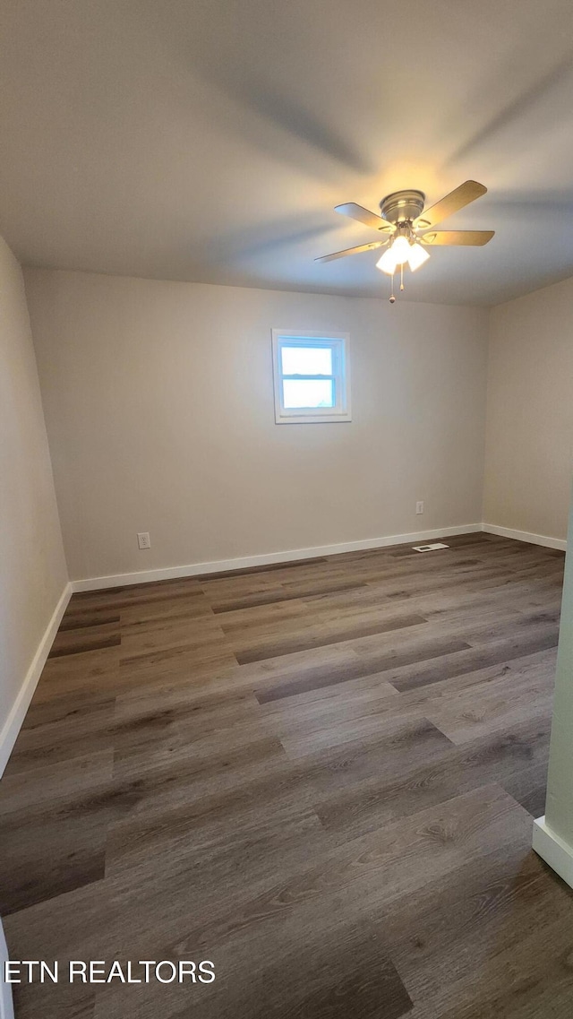 unfurnished room featuring dark wood-style floors, baseboards, and a ceiling fan