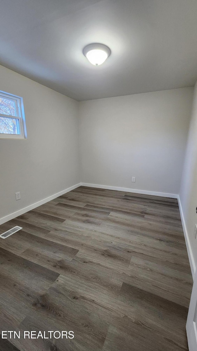 empty room featuring dark wood-type flooring