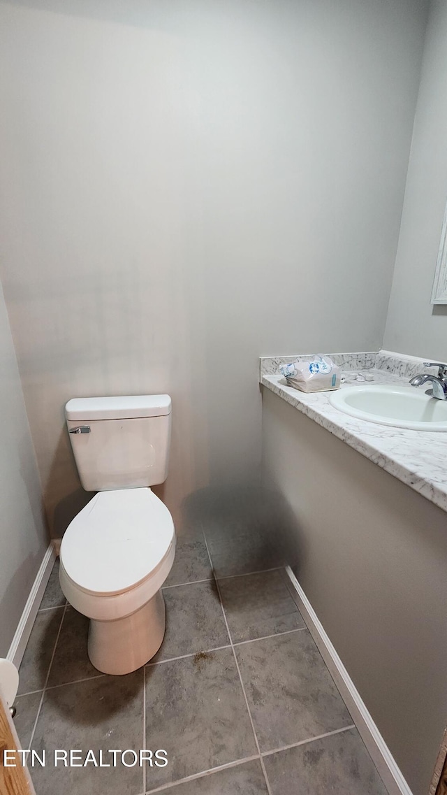 bathroom featuring tile patterned flooring, a sink, toilet, and baseboards