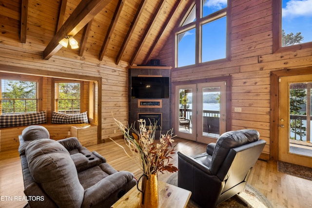 living room with light hardwood / wood-style flooring, wood walls, and a healthy amount of sunlight