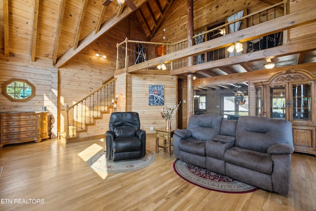 living room featuring hardwood / wood-style flooring, wood ceiling, wood walls, and high vaulted ceiling