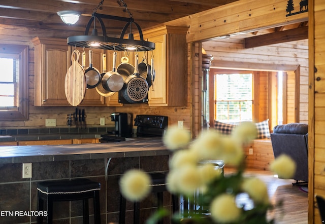 kitchen featuring black range with electric cooktop, tile counters, and a healthy amount of sunlight