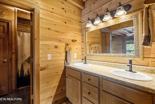 bathroom featuring tile patterned flooring, wood walls, and vanity