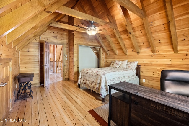 bedroom with wood ceiling, wooden walls, vaulted ceiling with beams, and light hardwood / wood-style floors