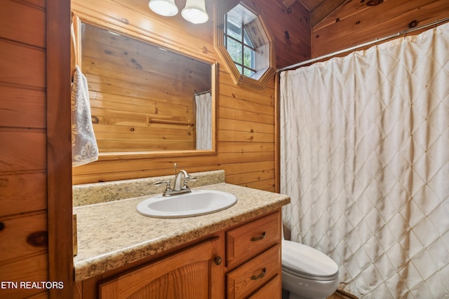 bathroom featuring wooden walls, vanity, and toilet