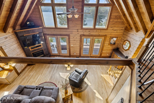 living room featuring high vaulted ceiling, wooden walls, beam ceiling, and hardwood / wood-style floors