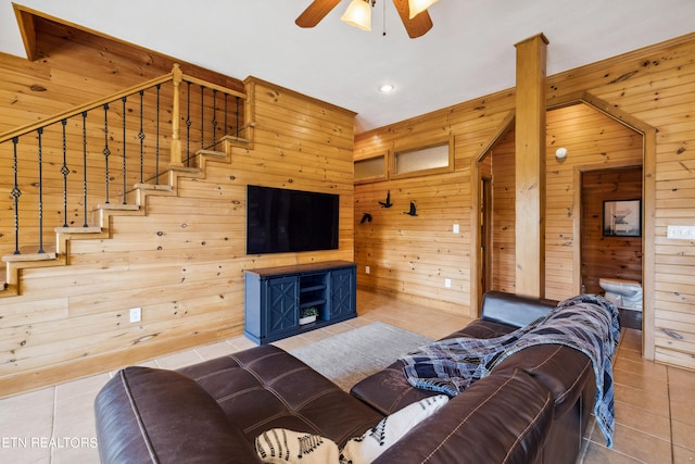 tiled living room with wood walls and ceiling fan