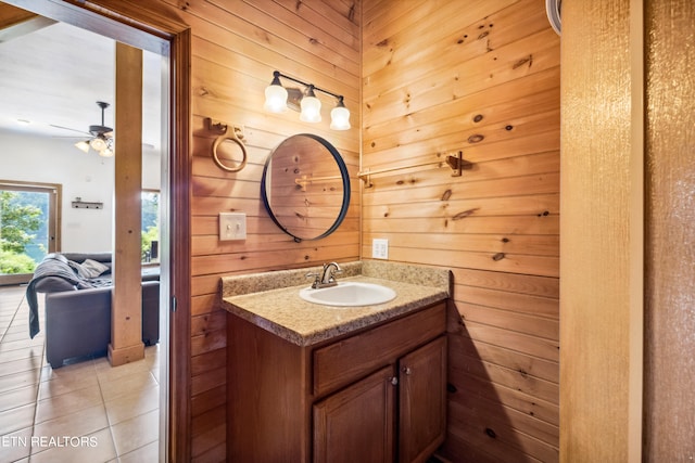 bathroom featuring tile patterned flooring, wood walls, ceiling fan, and vanity