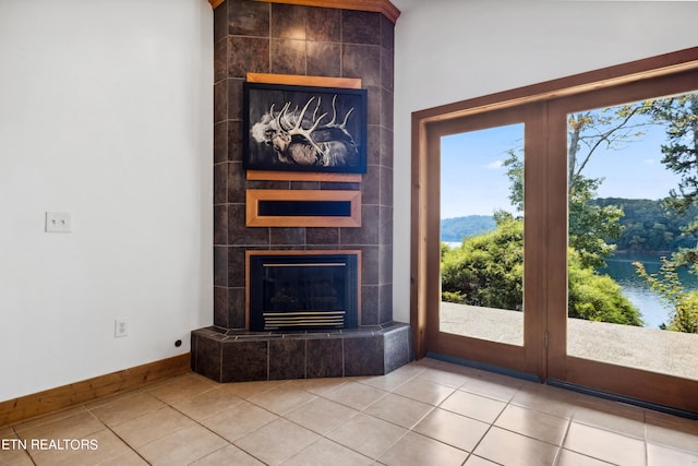 unfurnished living room with light tile patterned floors, a healthy amount of sunlight, and a tile fireplace