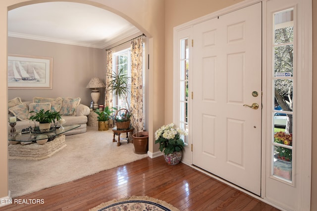 entryway with wood-type flooring and ornamental molding