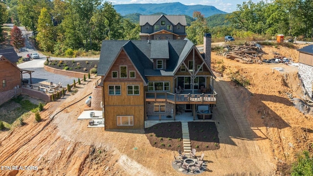 back of property with a deck with mountain view