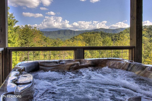 deck with a mountain view and a hot tub