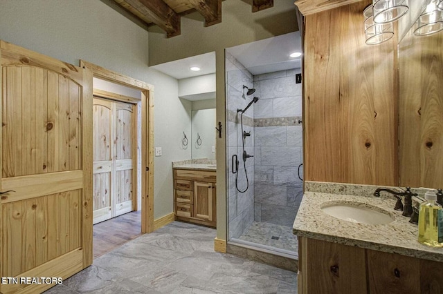 bathroom featuring beam ceiling, an enclosed shower, and vanity