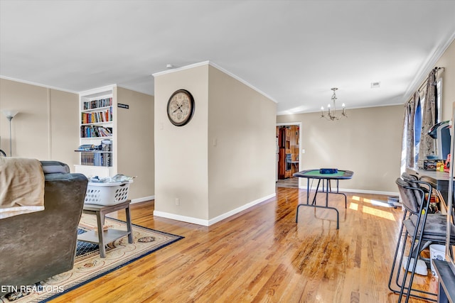 interior space with ornamental molding, a chandelier, and light hardwood / wood-style floors