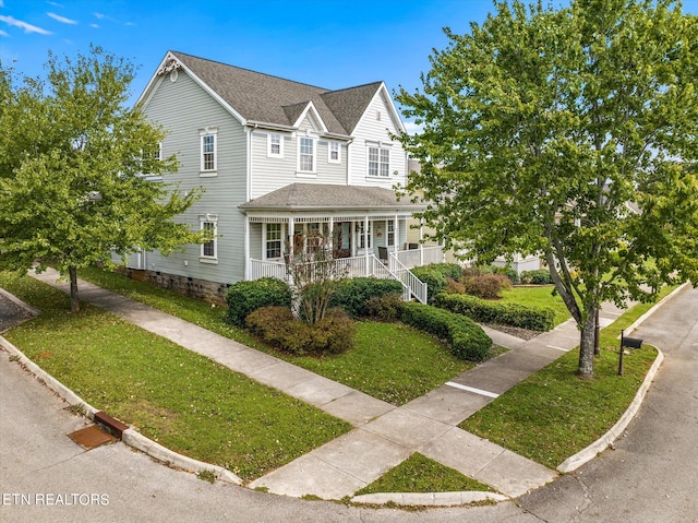 view of front of property featuring a front lawn and covered porch