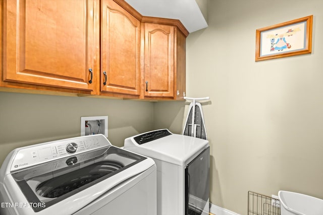 washroom featuring cabinets and washer and clothes dryer