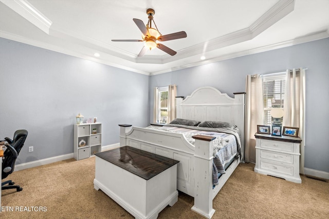 carpeted bedroom with crown molding, a tray ceiling, and ceiling fan