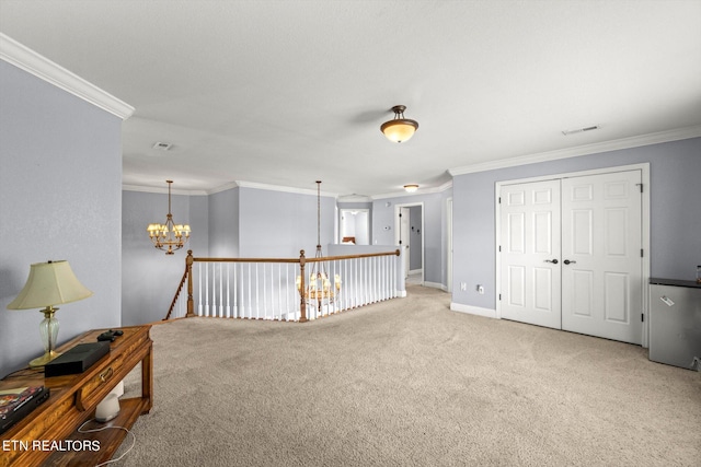 carpeted empty room featuring ornamental molding and a chandelier