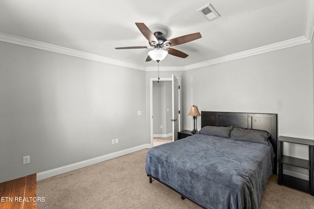 carpeted bedroom with ceiling fan and ornamental molding