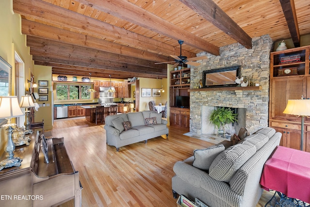 living room with wooden ceiling, a stone fireplace, light hardwood / wood-style flooring, and beamed ceiling