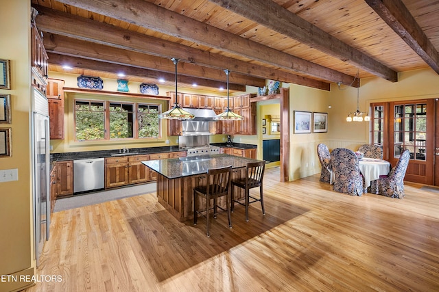 kitchen with appliances with stainless steel finishes, wooden ceiling, a wealth of natural light, and decorative light fixtures