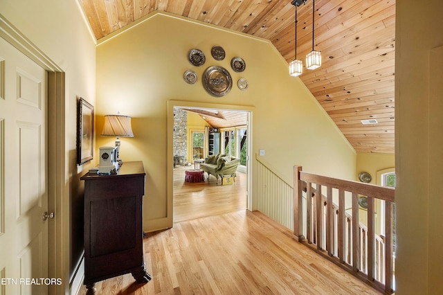 hallway featuring high vaulted ceiling, light hardwood / wood-style floors, and wooden ceiling