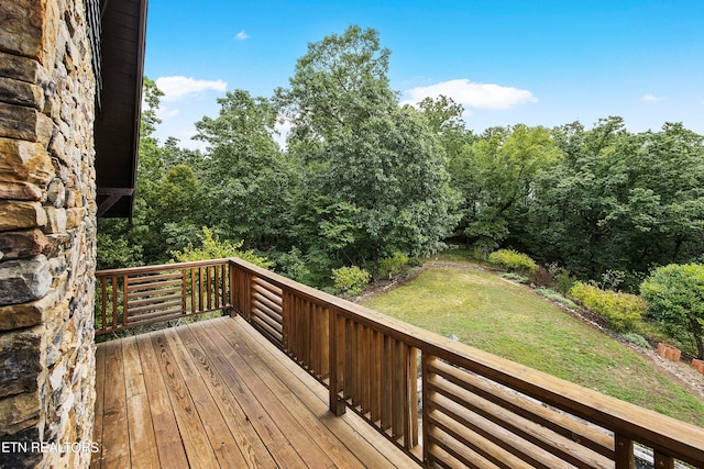 wooden terrace featuring a lawn