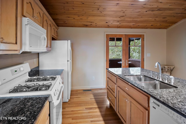 kitchen featuring dark stone countertops, light hardwood / wood-style floors, sink, and white appliances