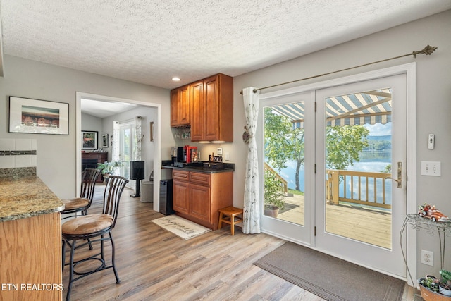 kitchen with a textured ceiling and light hardwood / wood-style flooring